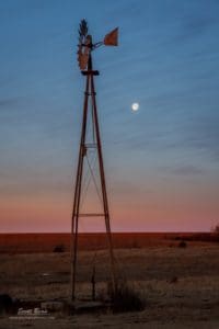 Photograph of moon set and a windmill.