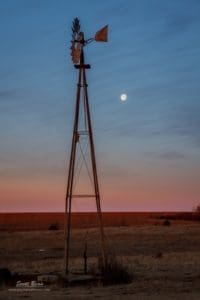 Photograph of moon set and a windmill.